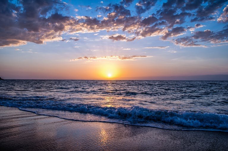 Captivating sunset over the ocean with vibrant colors, serene waves, and a peaceful sky.