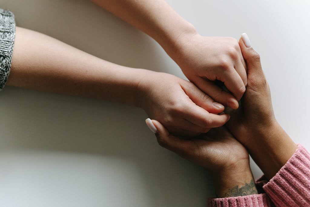 Close-up of diverse hands holding, symbolizing care, support, and friendship.