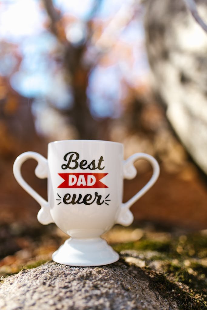 Decorative trophy-shaped mug with 'Best Dad Ever' message on rocky background, perfect for Father's Day gift.