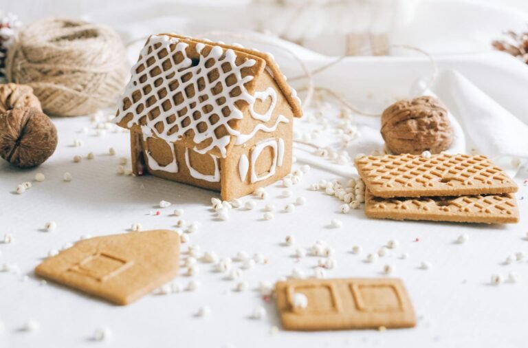 Minimalist gingerbread house surrounded by festive decorations on a white background.